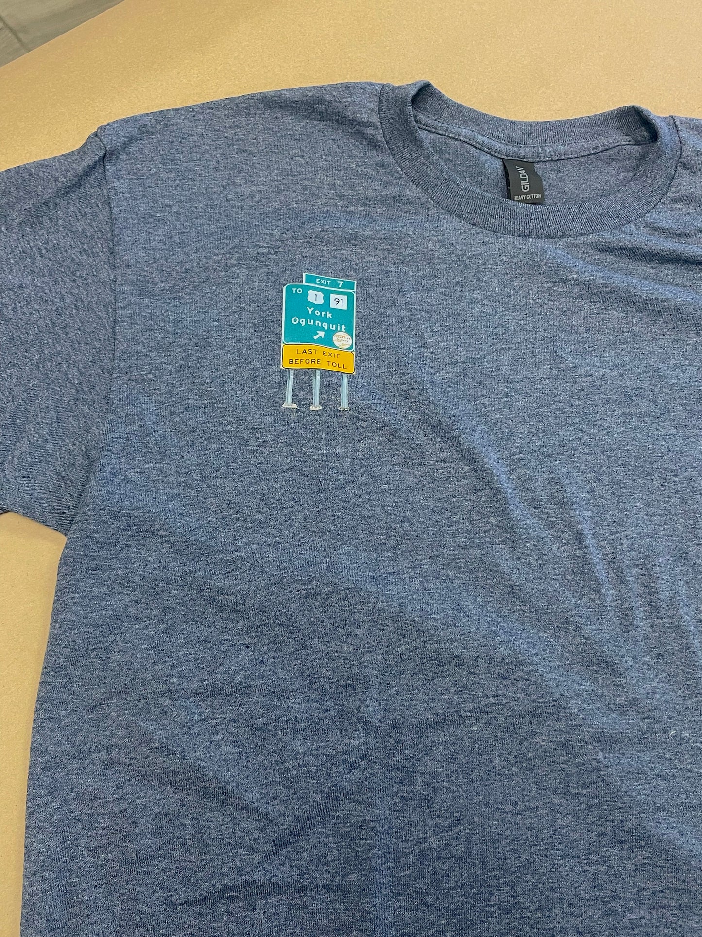 Blue t-shirt with a graphic design on a beige surface